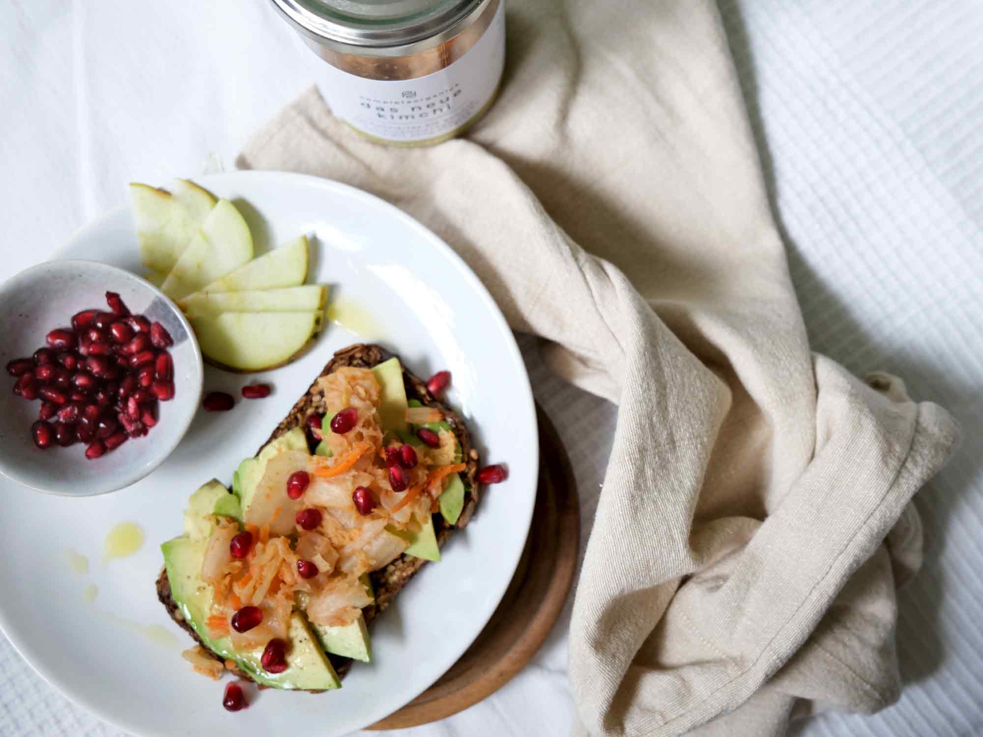 Avocadobrot mit mildes kimchi und Granatapfel