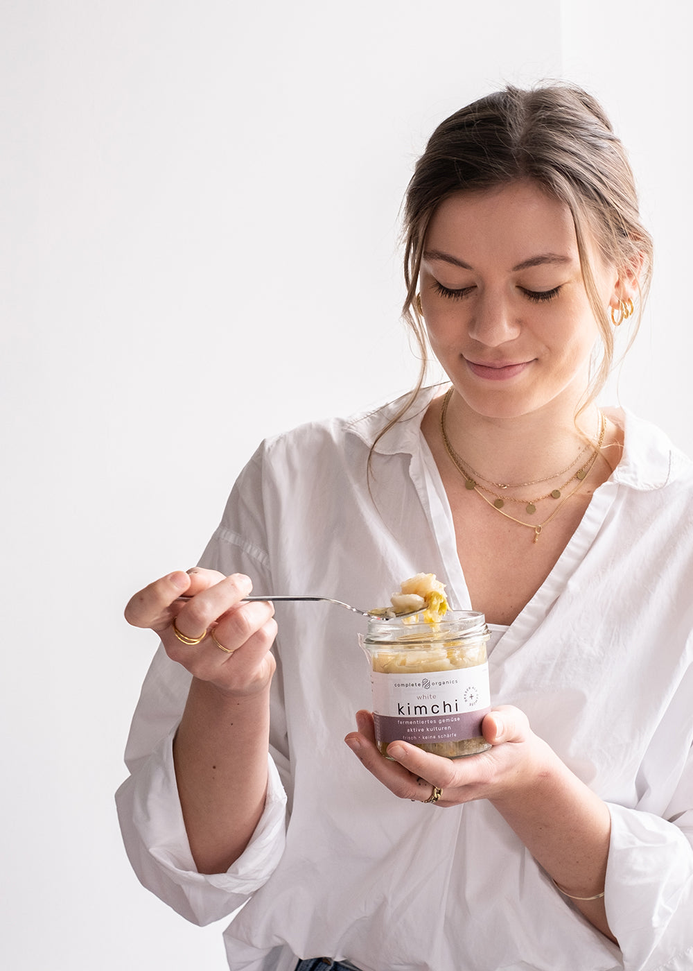 Frau mit fermentiertem white kimchi im Glas in der Hand