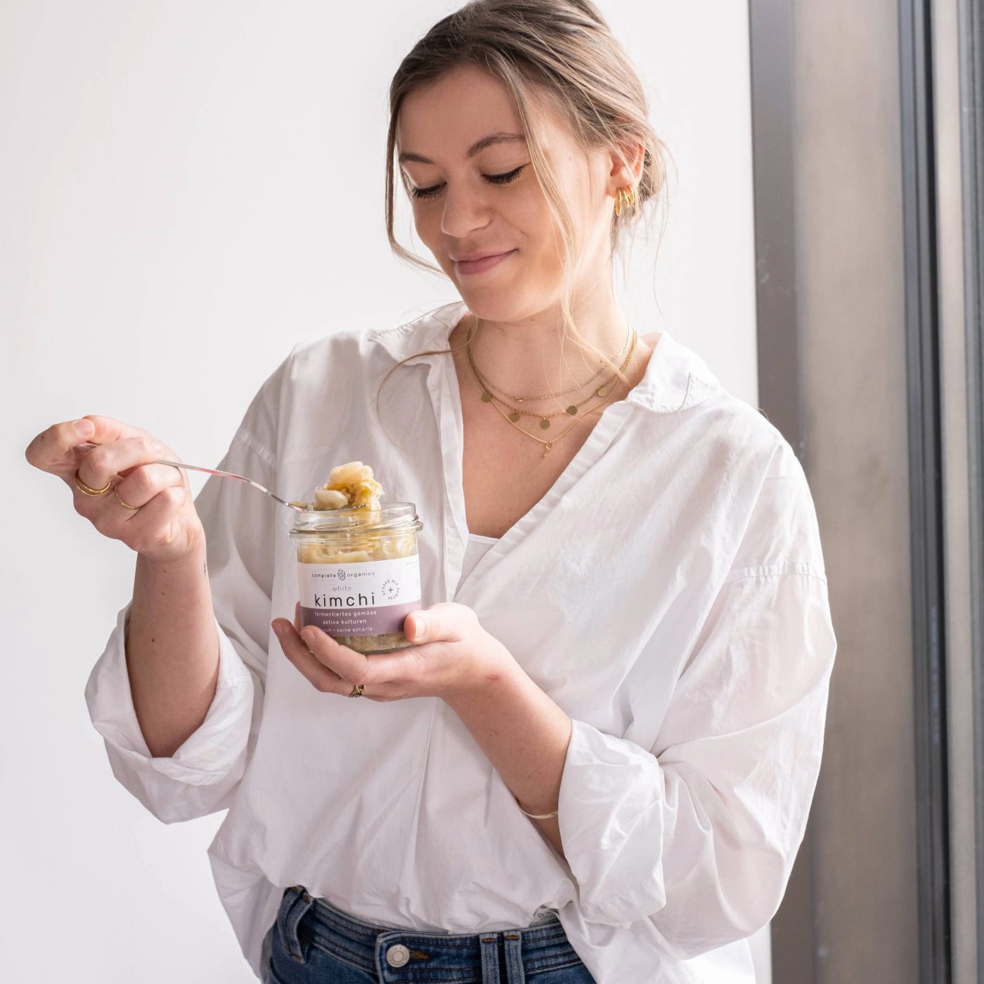 Frau hält white kimchi im Glas in der Hand