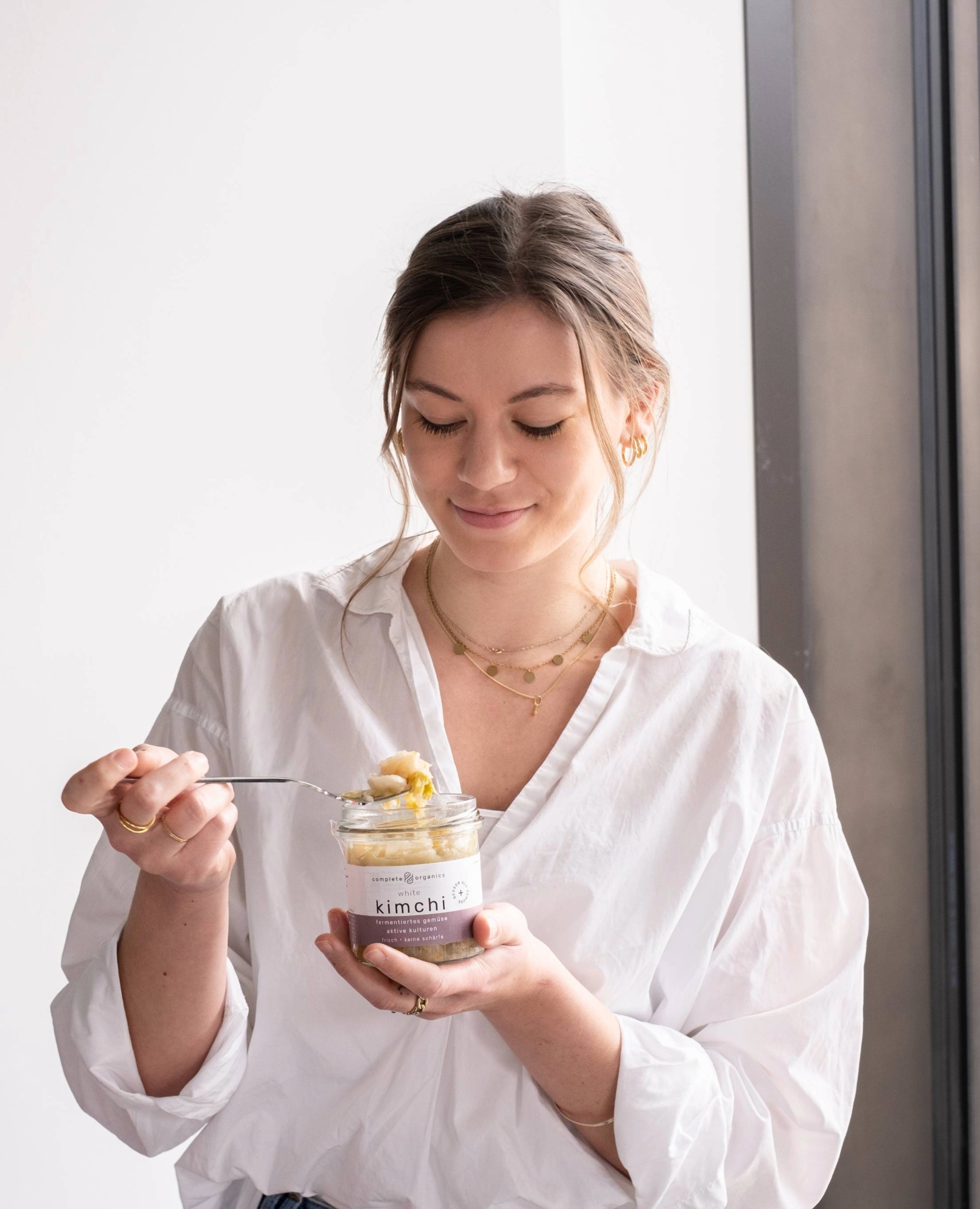 Frau hält white kimchi im Glas in der Hand