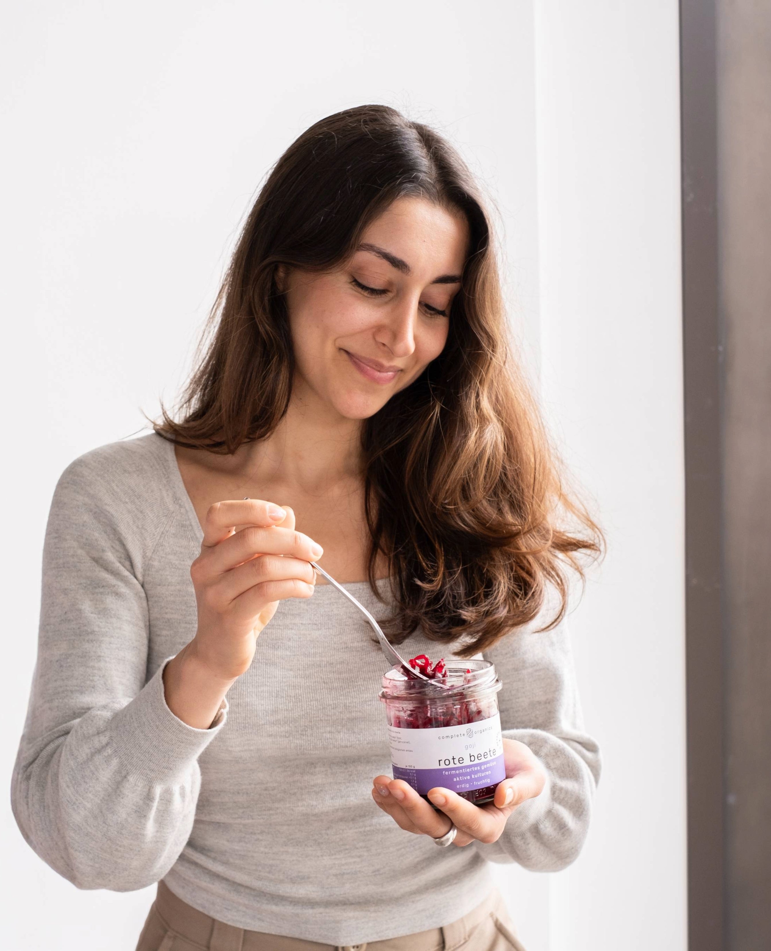 Frau hält fermentierte goji rote beete im Glas in der Hand