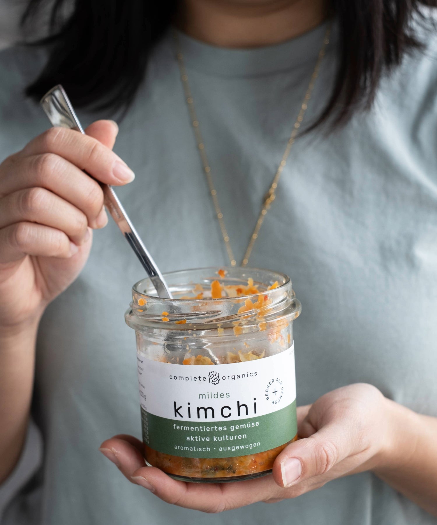Frau hält mildes kimchi im Glas in der Hand