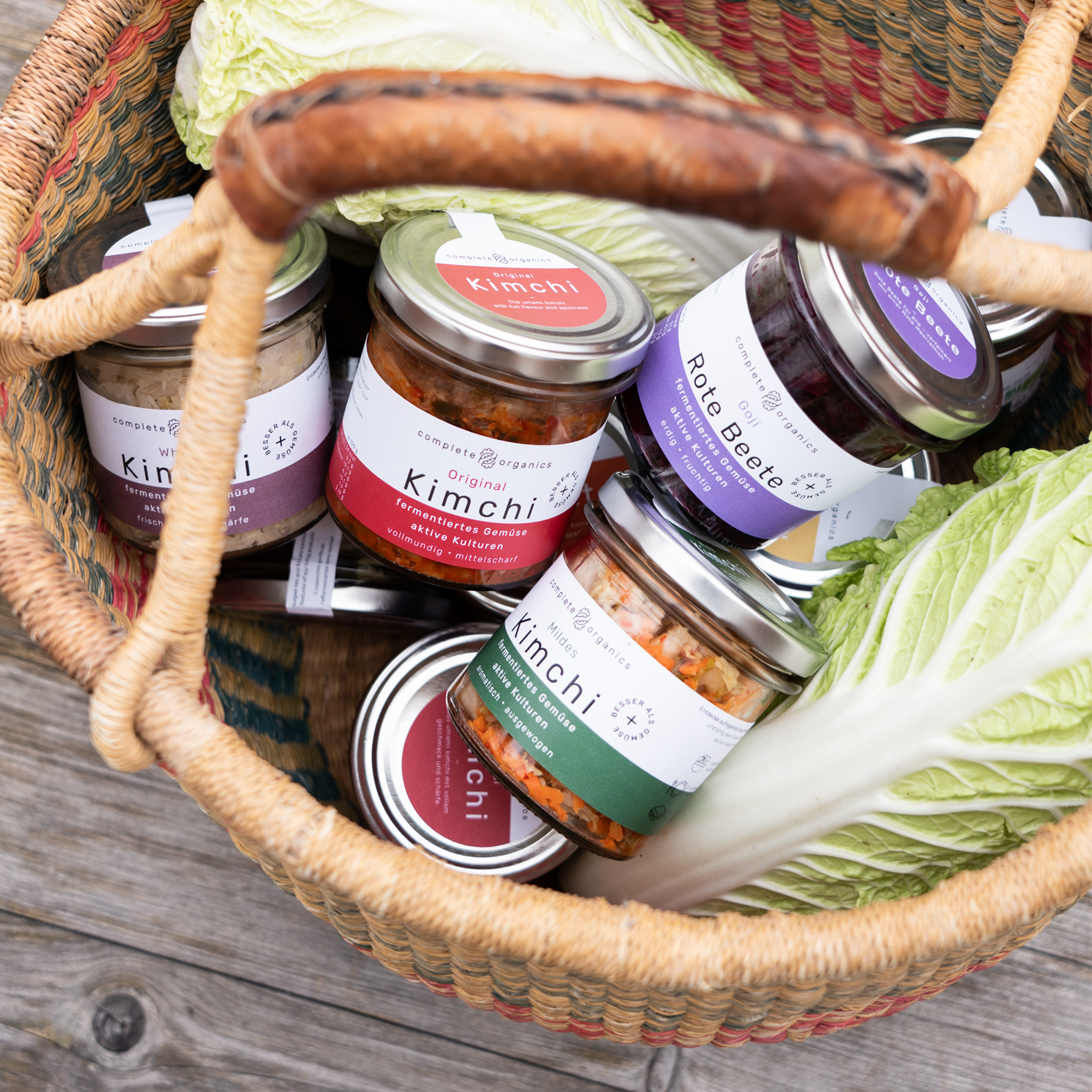7 Gläser fermentiertes Gemüse im Korb mit Chinakohl