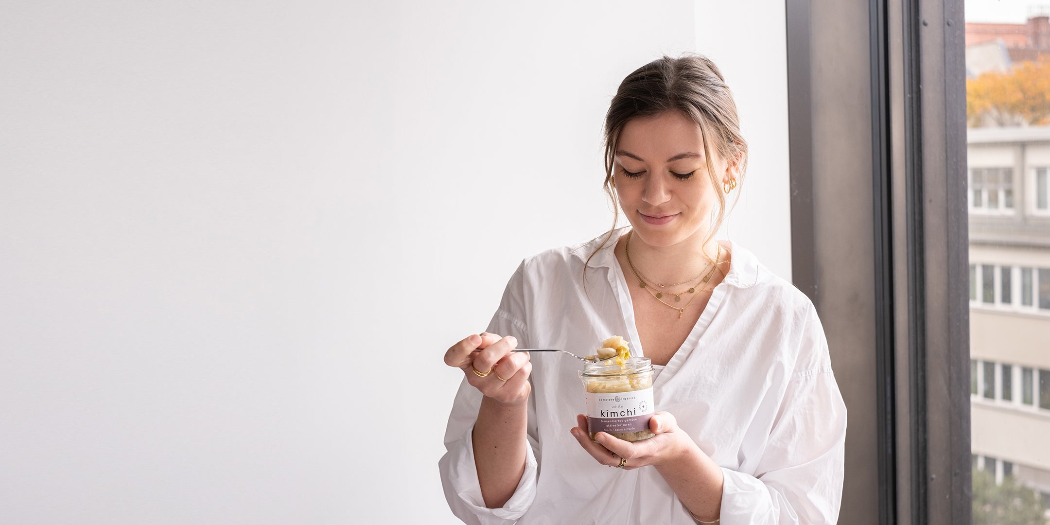 Frau mit fermentiertem white kimchi im Glas in der Hand